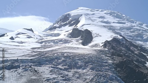Aerial Close-Up of Snow Covered Mont Blanc Summit with Rocky Peaks Under Blue Sky in French Alps