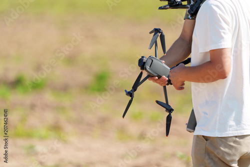 Drone pilot holding a quadcopter with smart remote controller 