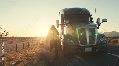 Frustrated truck driver calling for help on a desert highway at sunset