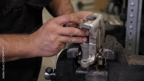 A detailed view of a mechanic. We secure a nut to a component of a machine using a vice. Fixing minor issues on a vehicle at a state-of-the-art repair facility.