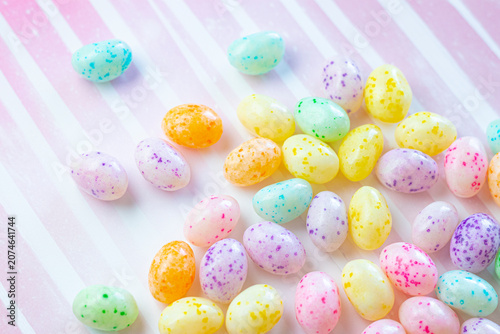 Colorful Speckled Jelly Beans on a Pink Striped Background