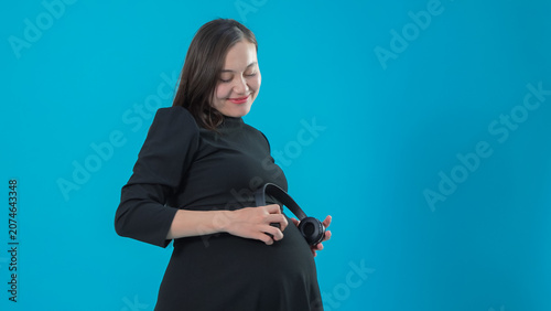 Foto Happy pregnant woman embracing stomach anticipating baby birth in studio