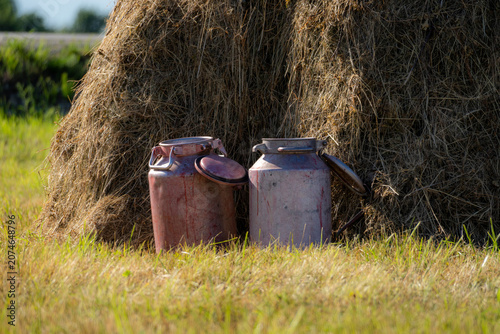 Photos Old Milk Cans Beside Traditional Haystack in Rural Farm Field, Dairy Farming Her