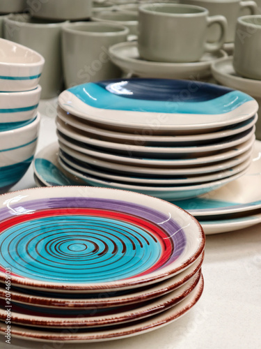 Plates and cups on shelves in store, close up of ceramic dish plates for kitchen and household