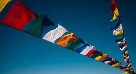 Colorful tibetan prayer flags blowing in the wind against blue sky