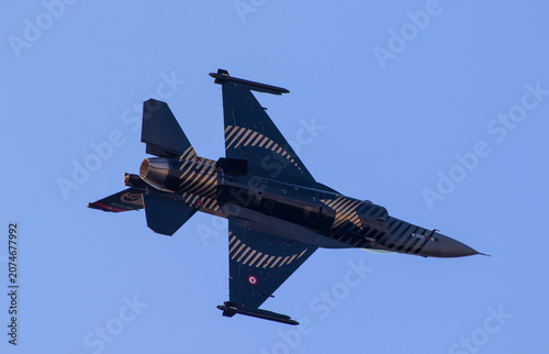 Картината върху платно Military F-16 fighter jet airplane performing high speed maneuver in the blue sk