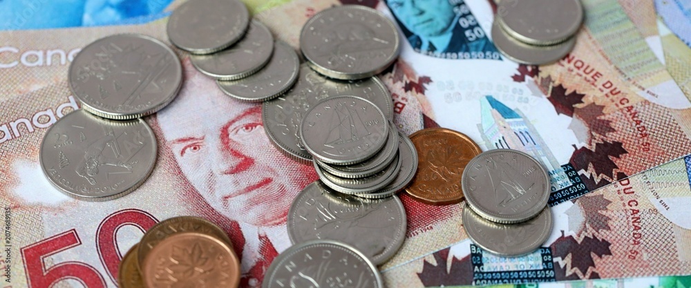 Obraz premium Canadian dollar money bills and coins on table. Canada cash of CAD currency close up
