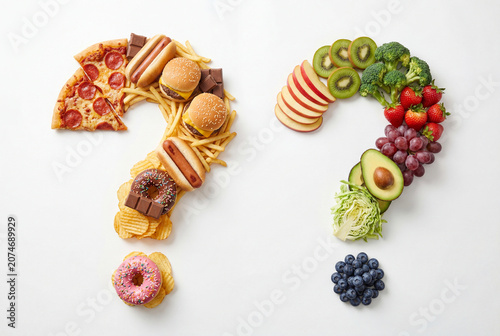 Two question marks composed of junk food and fresh healthy fresh produce