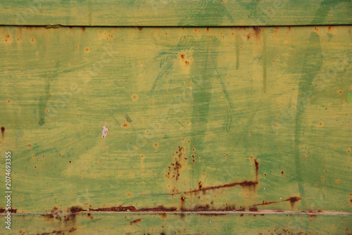 Old metal surface with peeling green paint, rust marks and weathered industrial details. Distressed texture background with strong urban character.