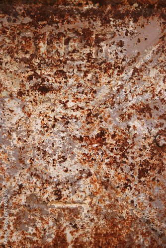 Close up of rusted metal surface with natural corrosion patterns and rich brown-orange tones. Industrial abstract texture background.