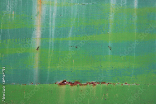Green painted surface with subtle weathering, scratches and color variations. Abstract background suitable for design, industrial and vintage concepts.
