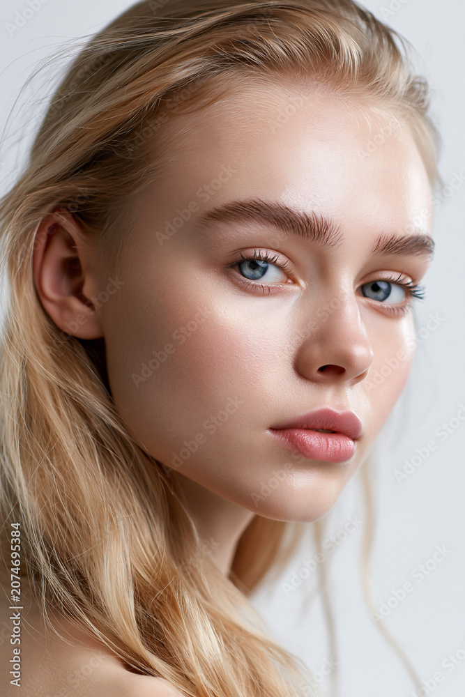 Naklejka premium natural beauty portrait of elegant blonde woman, closeup portrait of beautiful blonde female with blue eyes, sophisticated young blonde woman with minimal makeup