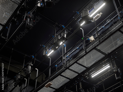 Foto Dark theater ceiling filled with lighting trusses, rigging and spotlights, the t