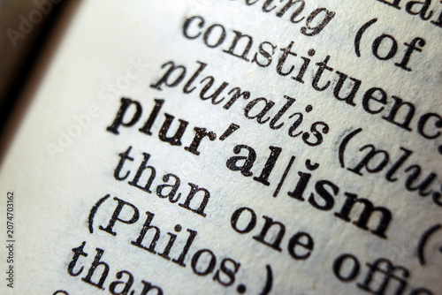 Foto Word pluralism on dictionary page, macro close up
