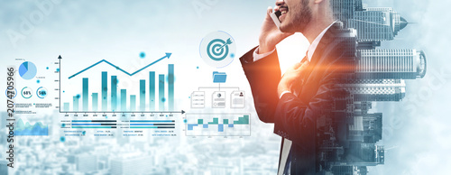 Fotografie Businessman Engaged in Phone Conversation with Growth Graphs and Charts in Urban Environment for Finance and Marketing Concepts Haptic