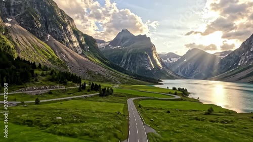 Winding road through mountain valley along a scenic lake.
