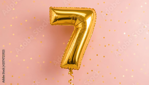 Seven year birthday. Number 7 flying foil balloon on pink. Seven-year anniversary gold confetti background. 3d rendering