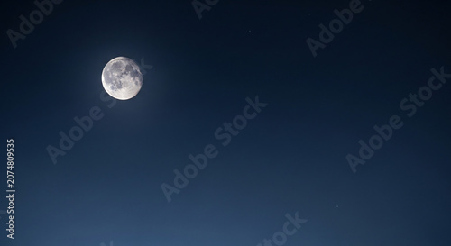 Bright Partially Illuminated Moon Against a Dark Blue Night Sky with Faint Stars