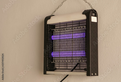 Photos Electric insect zapper with UV lamps and metal grid on a wall