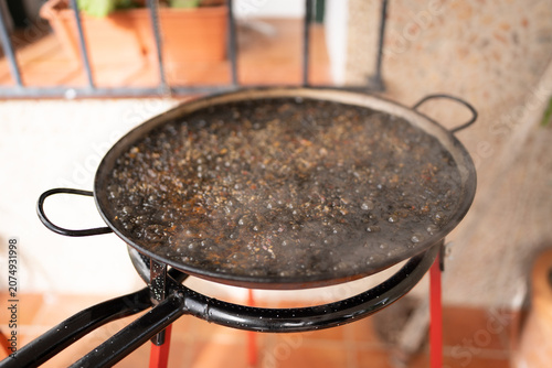 Foto Cooking traditional spanish arroz negro paella outdoors
