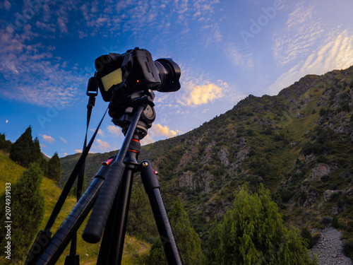 Photography Camera on tripod photographing mountain landscape at sunset