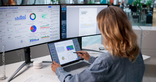 Mature Woman Uses Laptop To Monitor Corporate Compliance
