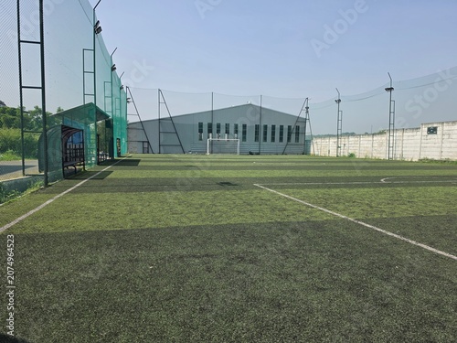 Aerial view of soccerfield at outdoor with blurred background. Sport photography concept design. Mini soccer arena at urban city with artificial green grass.