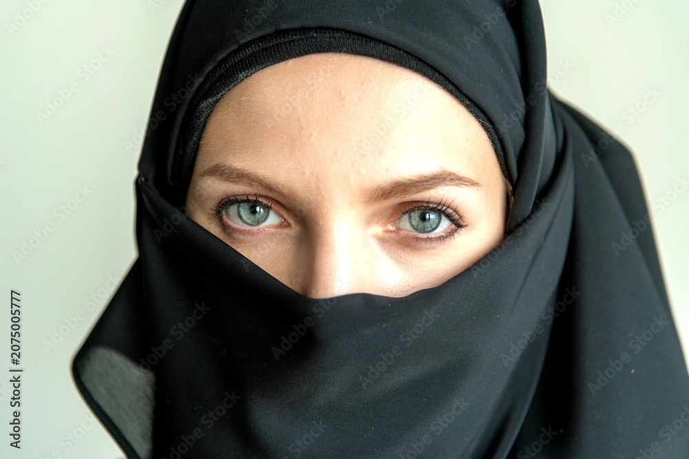 Naklejka premium Eyes framed by black fabric.