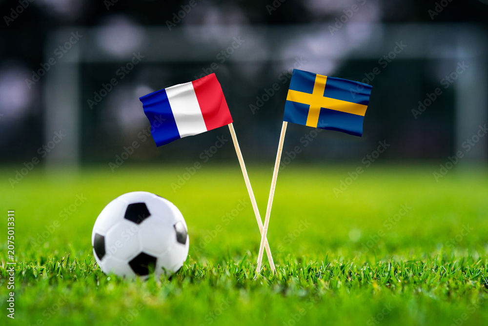 Obraz premium France vs Sweden, national flags before international football tournament Round of 32 match, football on green grass with goal in the background, East Rutherford, New Jersey, USA, June 30, 2026