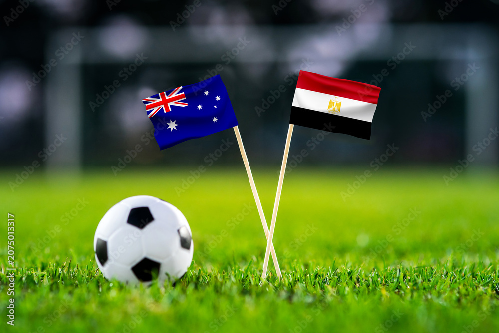 Obraz premium Australia vs Egypt, national flags before international football tournament Round of 32 match, football on green grass with goal in the background, Arlington, Texas, USA, July 3, 2026