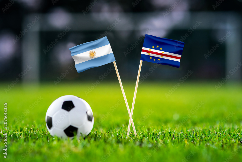 Obraz premium Argentina vs Cape Verde, national flags before international football tournament Round of 32 match, football on green grass with goal in the background, Miami Gardens, Florida, USA, July 3, 2026
