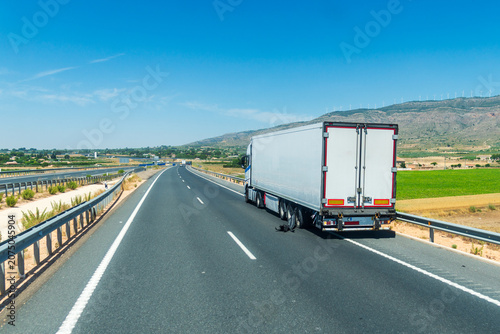 Refrigerated truck stopped on highway shoulder after trailer tire blowout