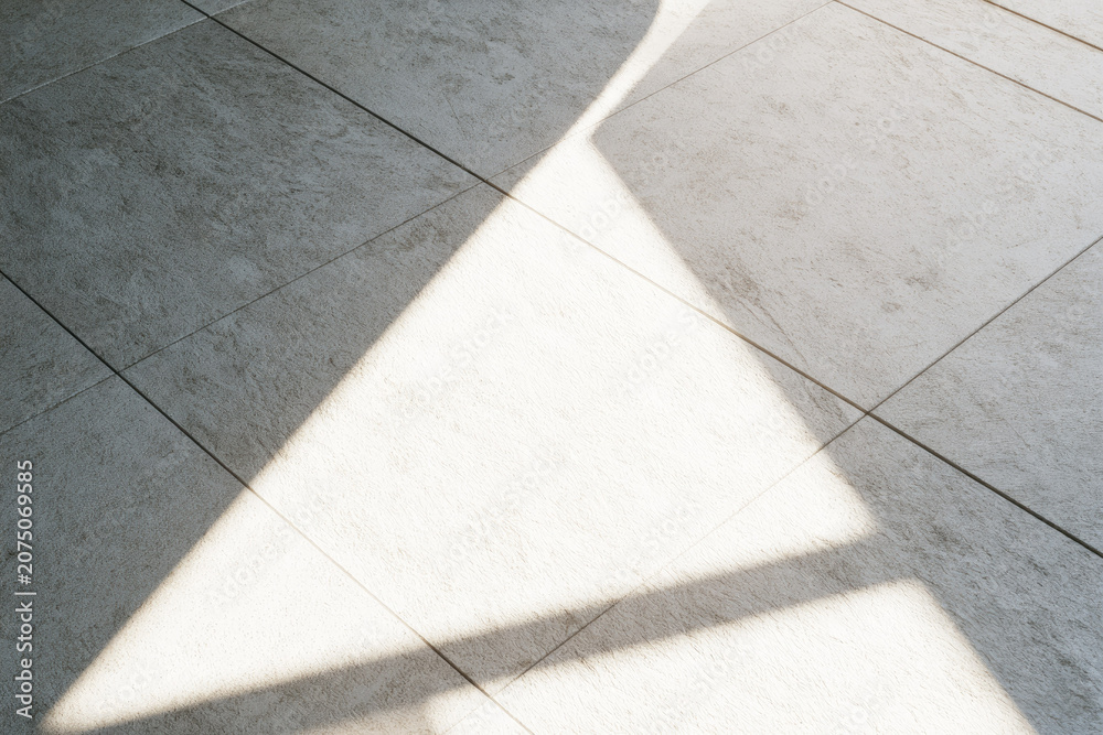 Fototapeta premium Sunlight clean tile floor bright beam minimalist surface copy space fresh sanitation empty space indoor light shadow line white tile gray tile clean floor beam of light geometric pattern abstract