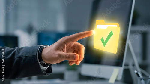 Businessman pointing at glowing checkmark on computer screen in office