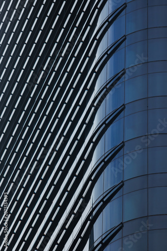 фотографія A modern skyscraper facade featuring sleek glass panels and structured steel louvers