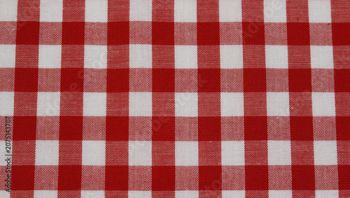 Close up of red and white checkered fabric. Texture of classic red gingham cotton cloth background. 