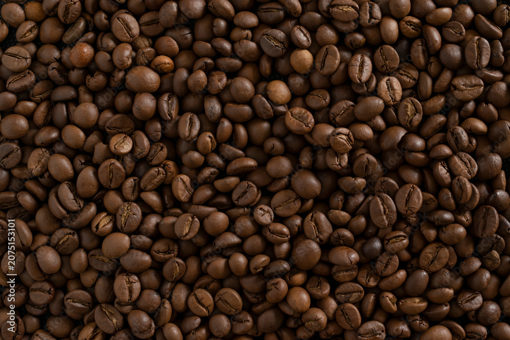 Fototapeta premium Roasted coffee beans background. Full frame close-up texture of dark brown aromatic coffee beans, ideal for wallpaper, banner, or food and drink backdrop.