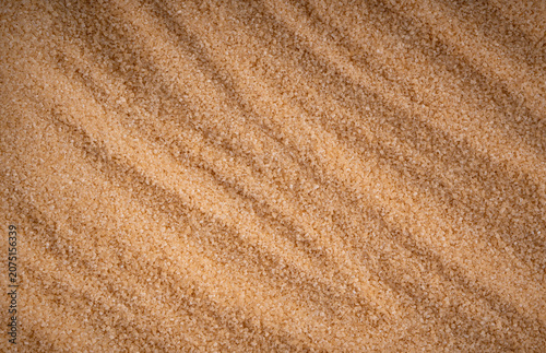 Brown cane sugar pile textured background top view