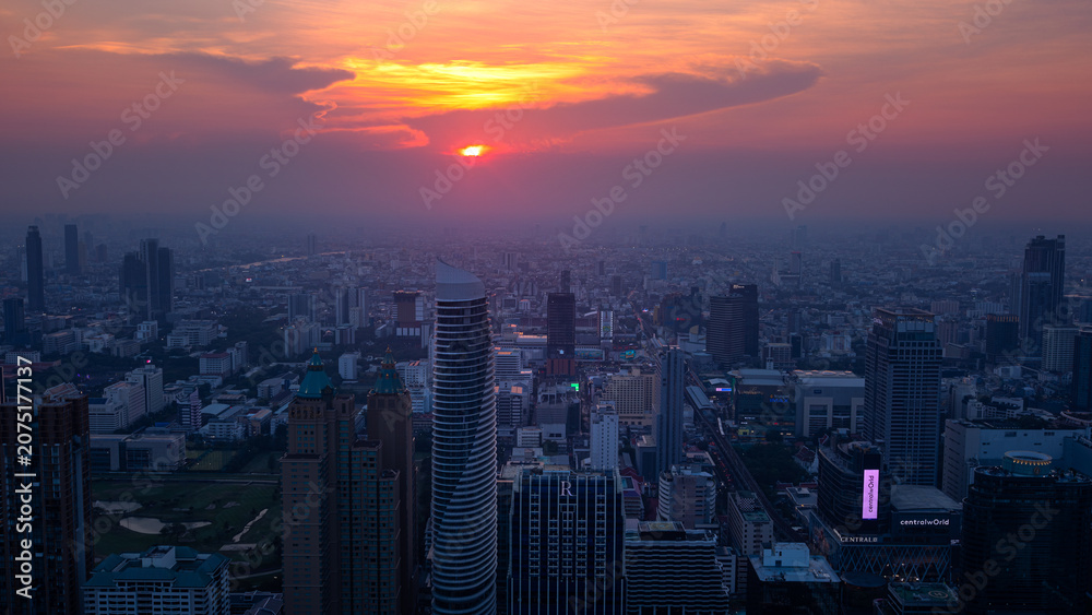Fototapeta premium Sunset over the Bangkok skyline from a rooftop bar in Thailand