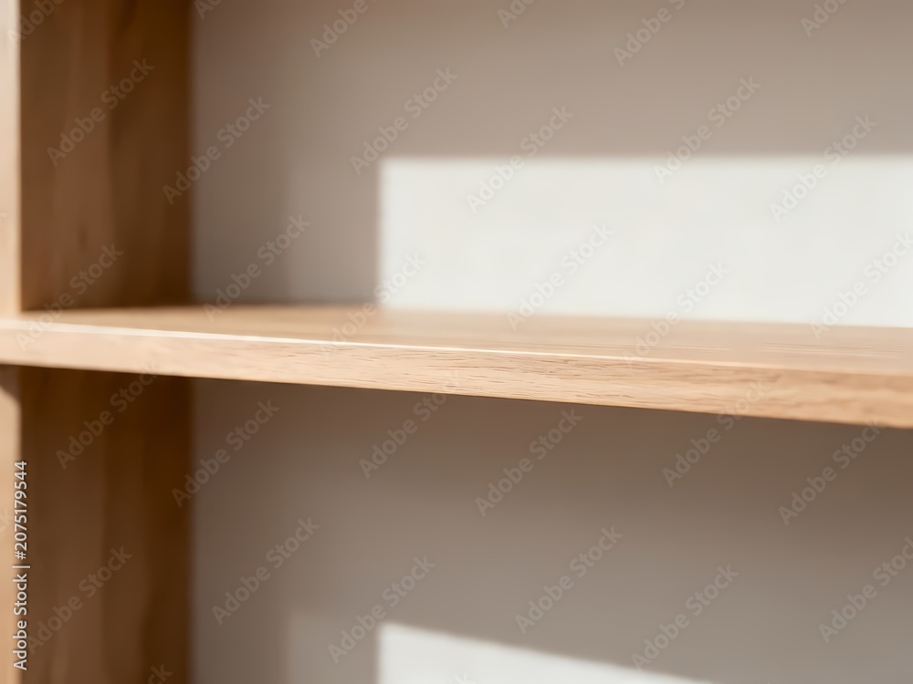 Fototapeta premium Minimalist Empty Wooden Shelves Against a Neutral Interior Wall with Soft Natural Sunlight and Sharp Shadows for Home Decor Display