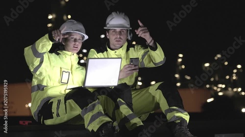 Oil and gas industry workers team using laptop for conducting site survey at petrochemical plant, Engineers reviewing plans at oil refinery, Technicians inspecting oil refinery plant