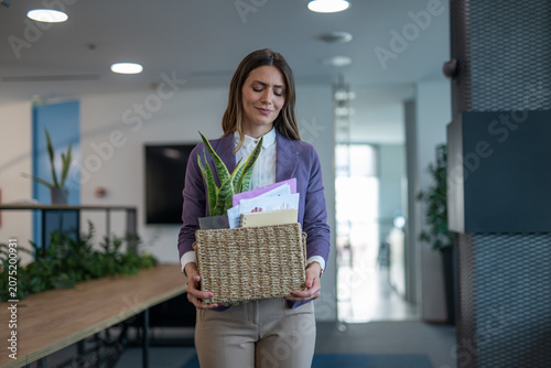 Obraz na plátne Woman carrying a box of personal items leaving the office after being laid off