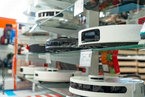 Exploring a Modern Selection of Robotic Vacuum Cleaners Displayed Neatly on Glass Shelves in an Innovative Home Appliance Store