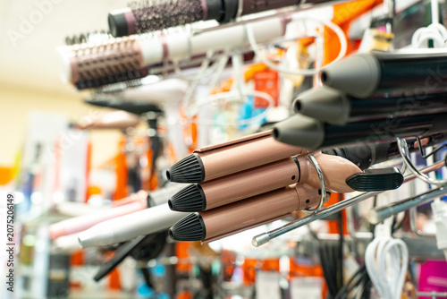 A Display of Various Hair Styling Tools Including Curling Irons, Straighteners, and Hairdryers in a Hair Salon Equipment Shop