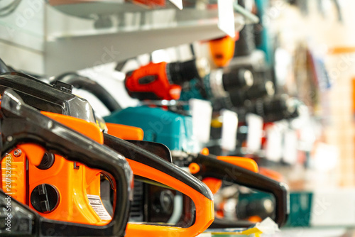 An Array of Power Tools Displayed on a Wall Shelf, Showcasing Various Models of Chainsaws, Drills, and Other Equipment for Home and Garden Improvement
