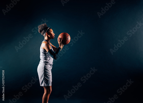 Side view of a basketball player preparing to shoot a ball