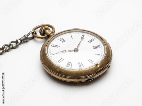 Vintage pocket watch with Roman numerals, brass patina, oxidized chain, white seamless background, ultra-realistic macro product shot.