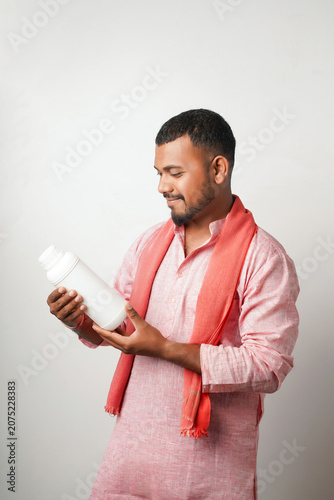 Happy indian farmer showing fertilizer  or pesticide bottle
