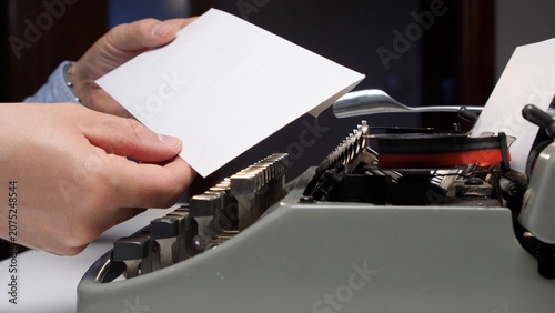 Canvas Print Hand inserting a blank sheet of paper into the platen of an antique manual typew