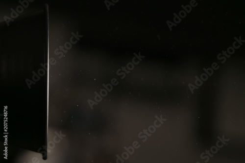 Fotografie real dust particles floating in room with harsh light from light fixture
